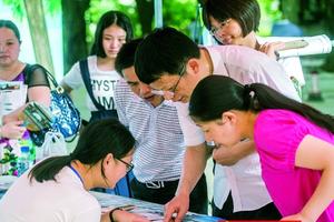 昨日，考生和家长来到南方医科大学校本部，在招生咨询摊位前询问。南都记者 谭庆驹 摄