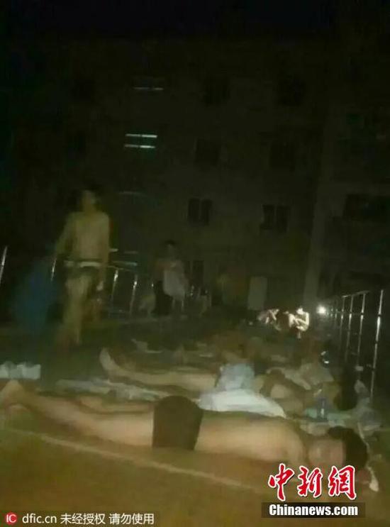 2016年6月20日，在河南省洛阳理工学院内的室外走廊上，大学生为避暑在地板上集体裸睡，近日洛阳持续高温，洛阳理工学院宿舍没有空调，学生只有结伴到学校内的走廊上睡觉，附近高楼上的女学生不敢往下看。王友摄 图片来源：东方IC 版权作品 请勿转载