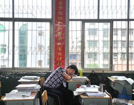 2013年6月2日，株洲市一中学，一位高三学生在写着高考的标语下睡着了。视觉中国供图（资料图片）
