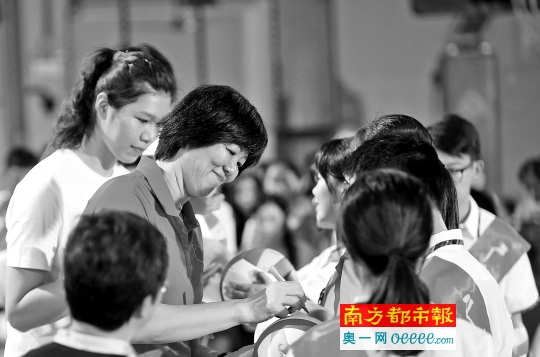 郎平和两名女排队员徐云丽、袁心玥为广雅中学师生送上亲笔签名的12个排球。 南都记者 马强 摄
