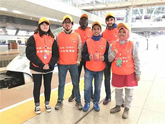 外国志愿者在展台前与高铁列车合影。新华社记者吴植摄