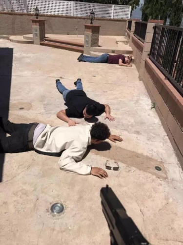 屋主张岩用枪将3名窃贼制伏趴在地上。(图：美国《世界日报》)