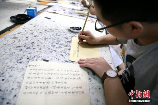 5月21日，在陕西咸阳师范学院于右任书法学院内，数十名大学生手执毛笔用小楷书写着家书。张远 摄