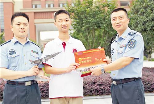 7月8日，重庆八中学生李成林同学（中）收到我市今年高考第一份录取通知书。