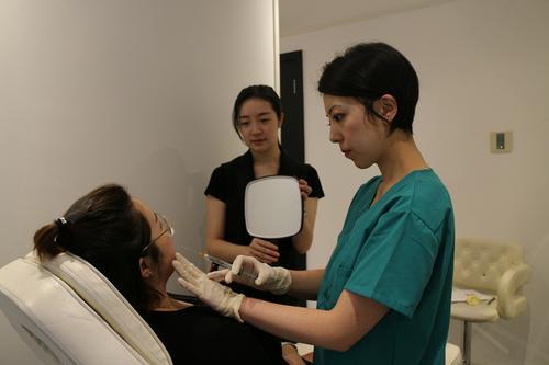 Ai Beauty的整形医生Dr. Lau（右一）正在给病人注射。（法国《欧洲时报》/季欧哲 摄）