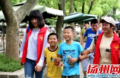 志愿者带盲童游玩