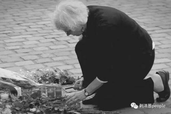 ▲悼念活动现场，一位头发花白的德国女士，为李洋洁点燃了一支蜡烛。