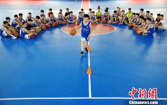 7月11日，在江西省万载县金锐篮球训练馆，一位学生正在教练指导下进行篮球训练。　邓龙华 摄