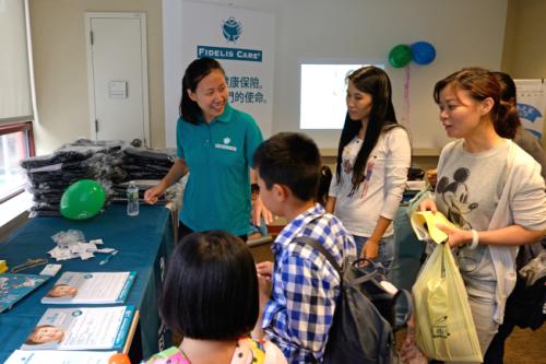 林Angie(左一)提醒申请儿童健保计划的父母主动续保。(美国《世界日报》记者朱泽人／摄影)