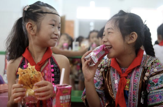 9月5日，在广西融水苗族自治县第三小学，苗族学生在吃免费营养早餐。视觉中国供图