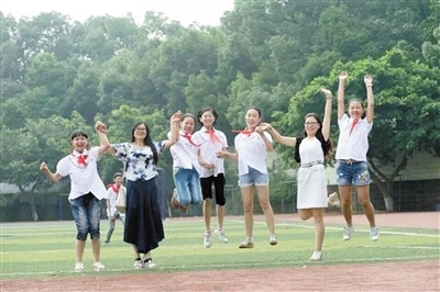 萱花小学老师罗孝平和学生在一起。