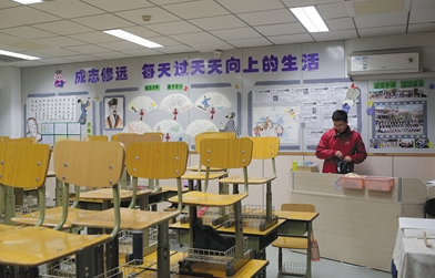 昨晚6点，清华附小2012级4班教室里，老师易博准备下班，他身后的墙上贴着苏轼的画像和诗句。新京报记者 朱骏 摄