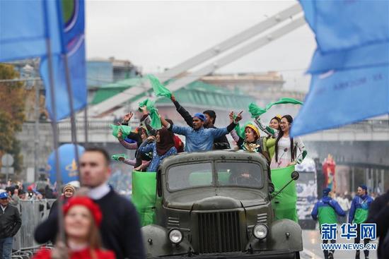 10月14日，青年乘坐花车参加狂欢游行。