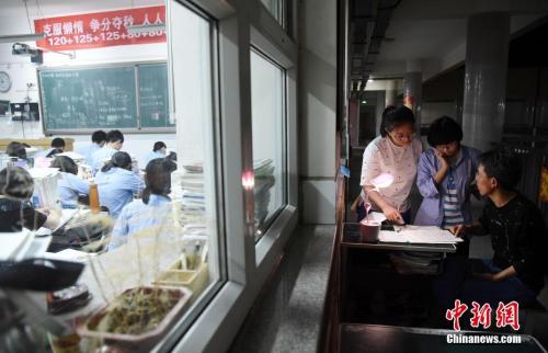 资料图：2018年5月23日晚，河北省邯郸市第一中学，高三学生在教室门口向老师问问题。 中新社发 郝群英 摄 图片来源：CNSPHOTO