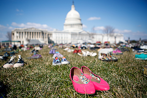 资料图：2018年3月13日，7000双代表自2012年美国康涅狄格州桑迪胡克小学枪击案以来枪击事件中遇难儿童的鞋子摆放在华盛顿国会山前的草坪上。（新华社）