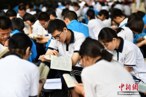 6月7日清晨，河北石家庄一高考点附近，参加高考的学生们利用进入考场前的时间看书复习。