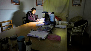 学生和老师都走后，章站亮在学校的办公室内备课（1月4日摄）。