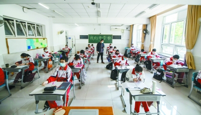 返校的高三学生在座位拉开间隔的教室里安心复习功课。