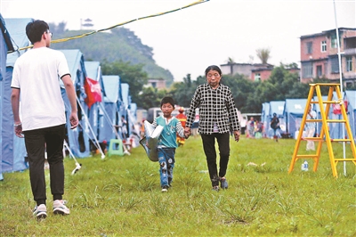 6月18日,小男孩帮奶奶拿着行李
