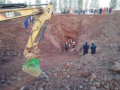 18日5时30分许，随着男童的腿部露出，救援人员加紧破除洞口周围岩石。 新京报记者 齐超 摄