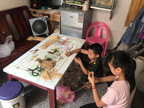 来自广东梅州的婉婷姐弟坐在不足十平米的客厅中制作手工项链补贴家用，姐弟俩平均每天要做1000个左右，一个仅赚两分钱。