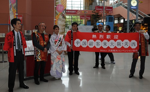 资料图：2011年10月1日，工作人员在日本大阪关西机场迎接中国游客。 新华社记者马兴华摄