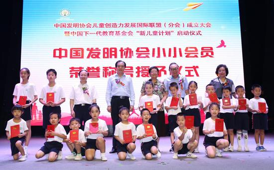 与会领导们为小朋友们颁发“中国发明协会小小会员”荣誉证书