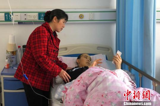杨晓龙浏览朋友发来鼓励他的信息 袁雪梅 摄
