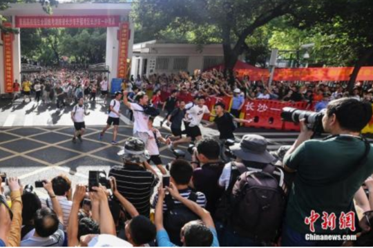 资料图:6月8日下午,湖南长沙市一中考点外,考生跑出考场,庆祝高考结束。 中新社记者 杨华峰 摄