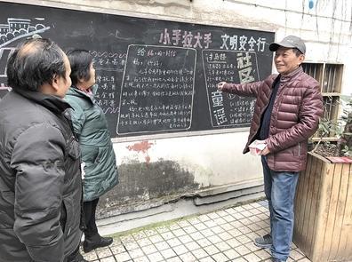 何光成向居民讲解自己的黑板报。 通讯员 高祎恩 摄