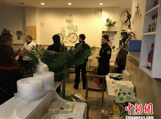 当地警方及相关部门正在餐馆进行取样调查。　杨勇 摄