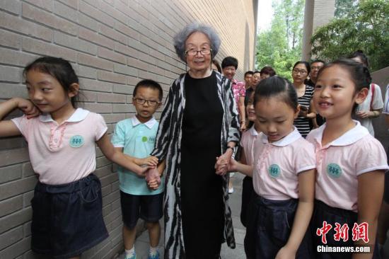 资料图：图为南开大学幼儿园的孩子们与叶嘉莹携手走进迦陵学舍。 中新社记者 张道正 摄