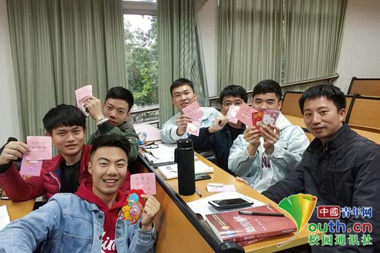 部分学生手持福利红包和陈飞(右一)老师合影。 中国青年网通讯员 郭政 图