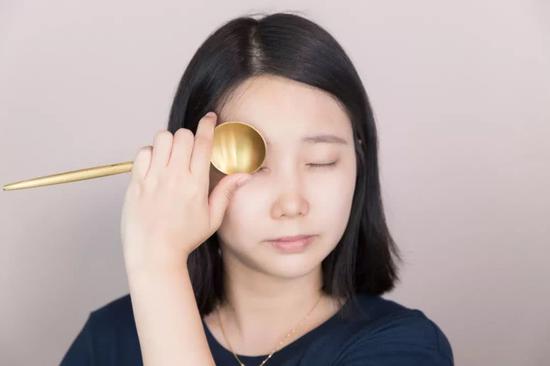 然后再依次用手指将睫毛贴近勺子,顺着勺子的弧度轻轻拈起睫毛。