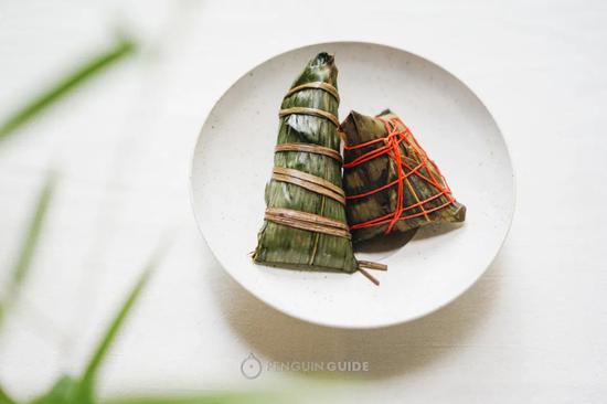 左边是传统肇庆碱水粽,呈长条枕头形;右边是新派版本,形状不一样,而且用彩色线包扎。