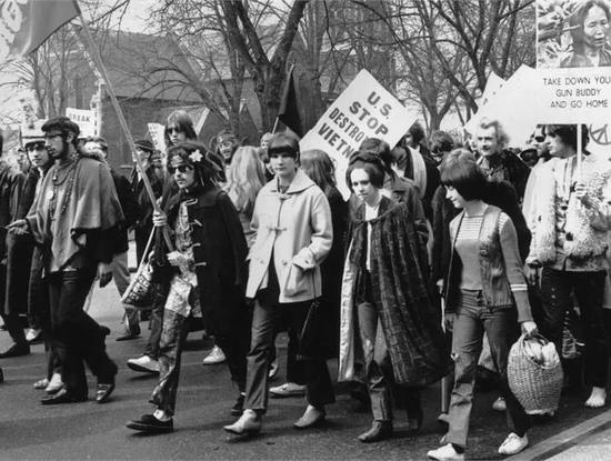 反对越南战争游行的队伍中，人们穿着牛角扣大衣