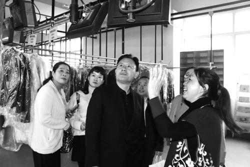 顾客开放日，吴云红（右一）向参观的顾客介绍工厂里的智能洗衣应用系统。