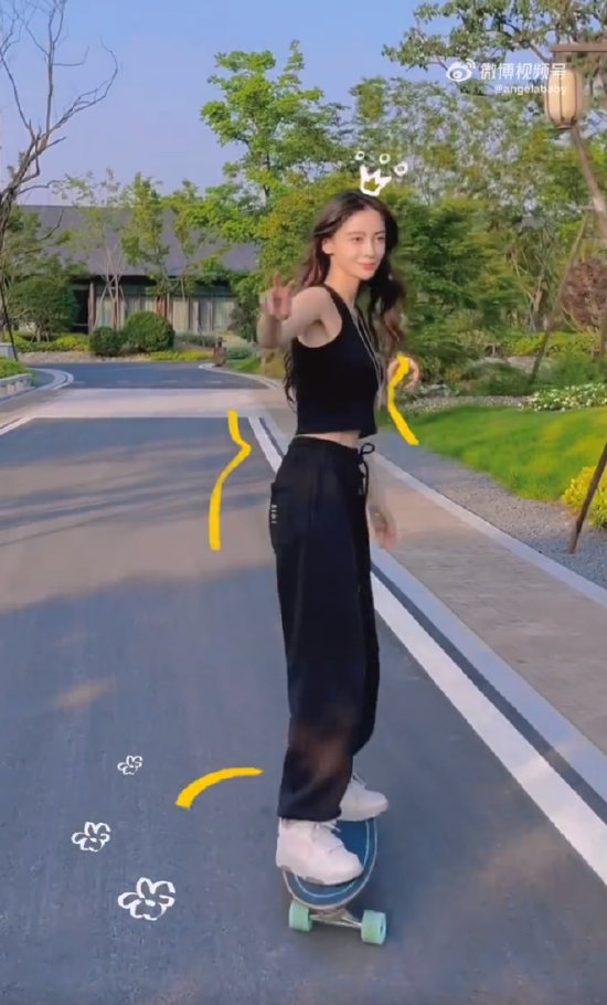 Angelababy晒街边玩滑板视频 对镜头比耶笑容甜美