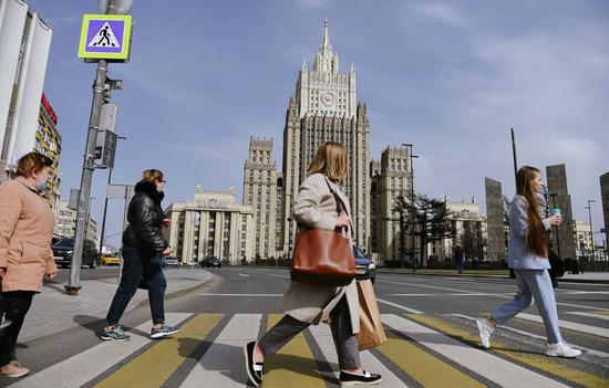 People cross the road in front of the Ministry of Foreign Affairs of Russia in Moscow, on April 16, 2021. (Xinhua/Evgeny Sinitsyn)