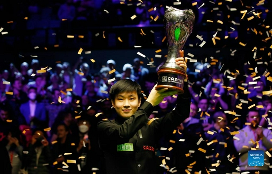 Zhao Xintong of China celebrates with the trophy after winning the final match against Luca Brecel of Belgium at 2021 UK Snooker Championship in York, Britain on Dec. 5, 2021. Zhao beat Brecel 10-5 and claimed the title. (Photo by Craig Brough/Xinhua)