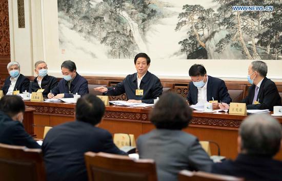 Li Zhanshu, chairman of the National People's Congress (NPC) Standing Committee, takes part in the group discussion to review the work report of the NPC Standing Committee, which will be submitted to the annual assembly of the legislature in March for deliberation, during the 26th session of the 13th NPC Standing Committee at the Great Hall of the People in Beijing, capital of China, Feb. 27, 2021. (Xinhua/Li Tao)