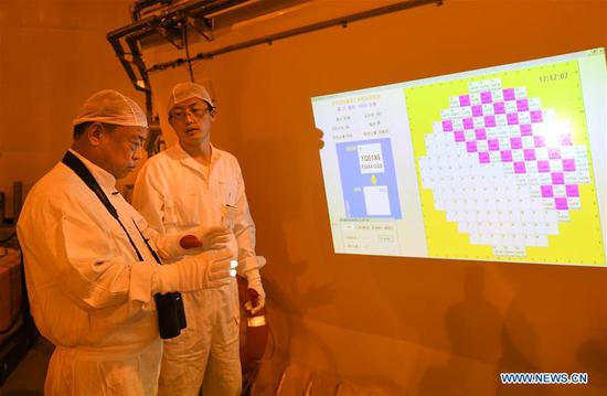 Qiao Sukai (L) learns about the condition of fuel assemblies replacement with his team member at the Dayawan Nuclear Power Plant in Shenzhen, south China's Guangdong Province, April 12, 2019. Every 18 months, the Dayawan Nuclear Power Plant has to undergo a fuel assemblies replacement, which is one of the most important moments for the nuclear power plant. Dozens of engineers are divided into four shifts and operate the equipment day and night when the reactor is shut down. Their leader, Qiao Sukai, has been dealing with nuclear fuel since July 1993 when the nuclear fuel assembly of Dayawan Nuclear Power Plant arrived. The professional and technical maintenance team led by Qiao is responsible for the maintenance of nuclear fuel for more than half of the nuclear power units in the country. Qiao and his team have successfully operated fuel installing and uninstalling more than 170 times without making a single mistake. (Xinhua/Mao Siqian)