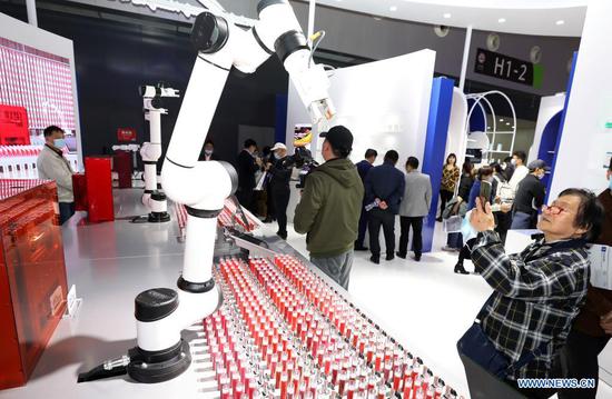 A visitor takes photos of a robot for customized lipstick production during the 8th China (Shanghai) International Technology Fair (CSITF) in east China's Shanghai, April 15, 2021. The 8th CSITF kicked off on Thursday. With an exhibition area covering 35,000 square meters, this year's fair has 5 different sections and has attracted over 1,000 exhibitors. (Xinhua/Fang Zhe)