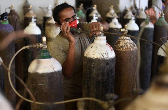 A worker fills medical oxygen cylinders used in hospitals in Prayagraj, India's northern state of Uttar Pradesh, April 19, 2021. (Str/Xinhua)