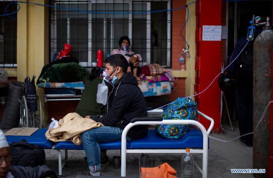 Patients infected with COVID-19 are seen outside the corridor of a hospital in Kathmandu, Nepal, on May 11, 2021. (Photo by Sulav Shrestha/Xinhua)