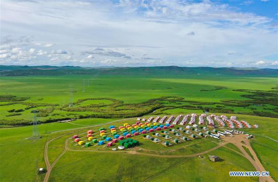 Aerial photo taken on Aug. 4, 2020 shows tourists visiting a scenic spot in Hulunbuir, north China's Inner Mongolia Autonomous Region. Local authorities in Hulunbuir have taken various measures, such as a more flexible working schedule and issuing tourist coupons, to boost local tourism market. (Xinhua/Xu Qin) 