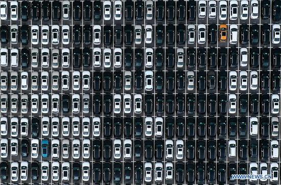 Aerial photo taken on Sept. 24, 2020 shows new vehicles parked at Dalian port in northeast China's Liaoning Province. Dalian port has been working on developing new shipping routes and growing its throughput as it seeks to further expand its market this year. (Xinhua/Yao Jianfeng)
