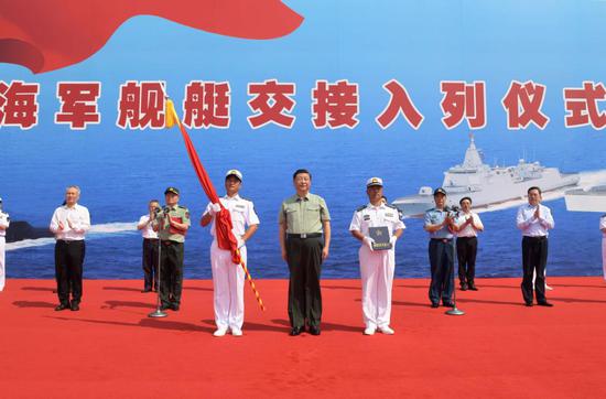Chinese President Xi Jinping, also general secretary of the Communist Party of China Central Committee and chairman of the Central Military Commission, presents People's Liberation Army (PLA) flag and the naming certificate to the captain and political commissar of the Dalian in Sanya, south China's Hainan Province, April 23, 2021. Xi attended the commissioning ceremony of three naval vessels, the Changzheng-18, the Dalian, and the Hainan, and boarded the vessels after the ceremony. The vessels were delivered to the PLA Navy and placed in active service on Friday at a naval port in Sanya, south China's Hainan Province. (Xinhua/Li Gang)