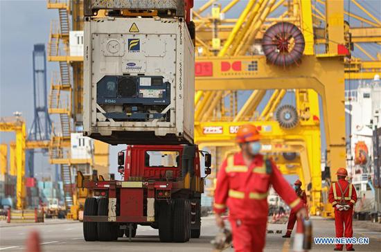 A truck is loaded with a container at Dalian port in northeast China's Liaoning Province, Sept. 24, 2020. Dalian port has been working on developing new shipping routes and growing its throughput as it seeks to further expand its market this year. (Xinhua/Yao Jianfeng)