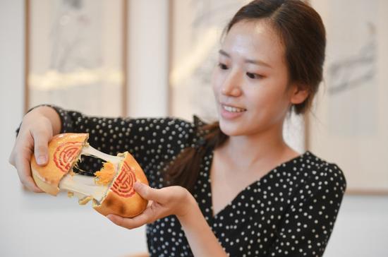 A customer tries a traditional pastry of a time-honored brand in Fuzhou, southeast China's Fujian Province, Sept. 25, 2020. (Xinhua/Song Weiwei)